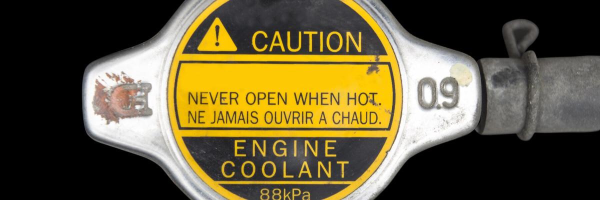 Engine coolant cap with caution label