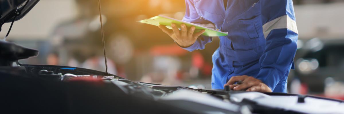 auto mechanic man holding a clipboard at workshop or warehouse, hybrid vehicle technician doing the checklist for repair or maintenance